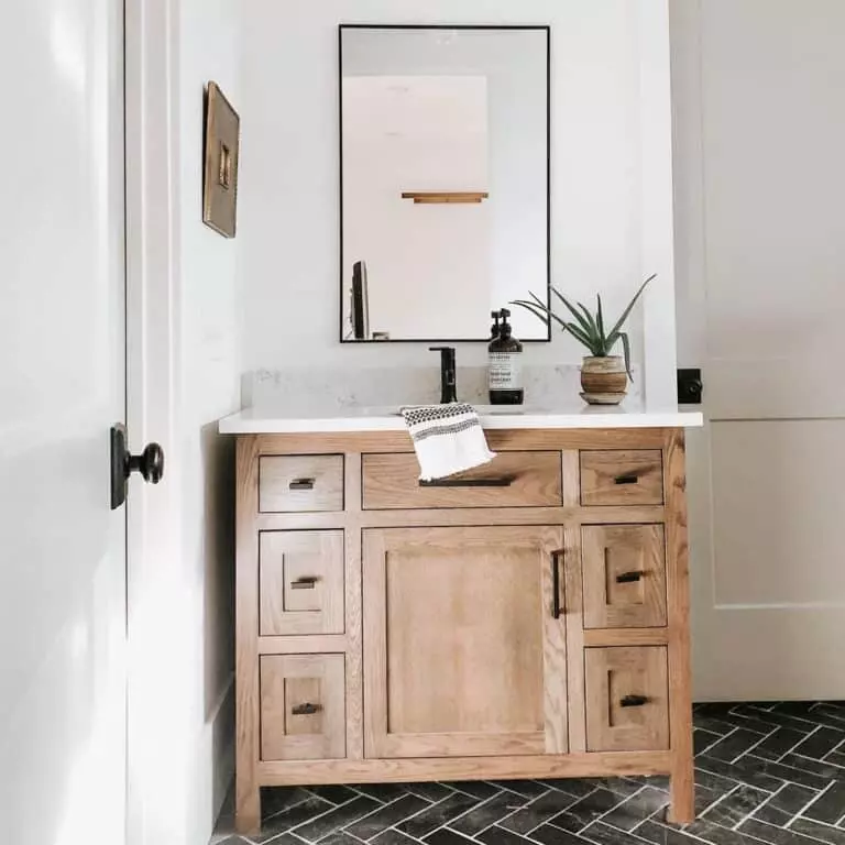 Light Wood Bathroom Vanity with Black Herringbone Floors